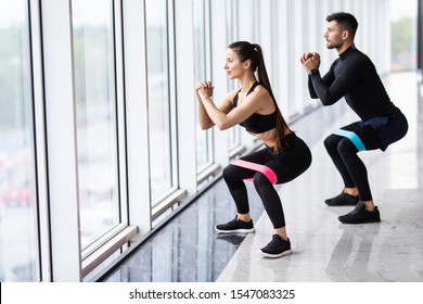 Attractive Couple Exercising With A Resistance Band In Gym As Part Of Fitness Bodybuilding Training