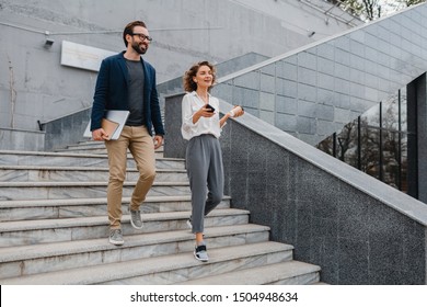 Attractive Couple Of Man And Woman Going On Stairs In Urban City Center In Smart Casual Business Style, Talking, Working Together, Smiling, Stylish Freelance People, Holding Laptop ,discussing