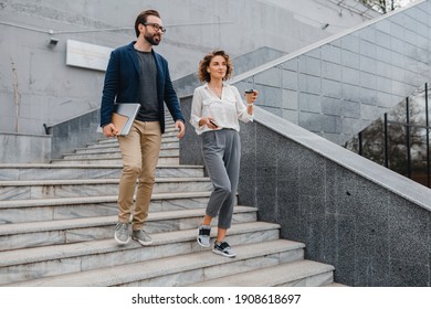 Attractive Couple Of Man And Woman Talking In Urban City Center In Smart Casual Business Style Working Together, Holding Laptop, Smiling, Stylish Freelance People, Discussing