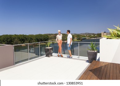 Attractive Couple On Luxurious Penthouse Balcony