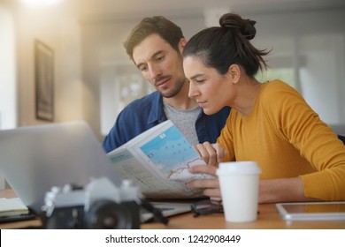  Attractive couple planning their trip looking at map at home                               - Powered by Shutterstock