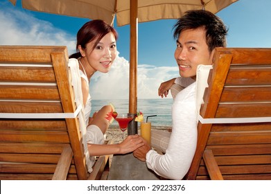 An attractive couple relaxing on the beach in deck chairs