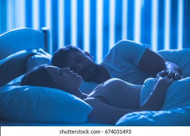 The Attractive Couple Sleeping In The Comfortable Bed. Night Time