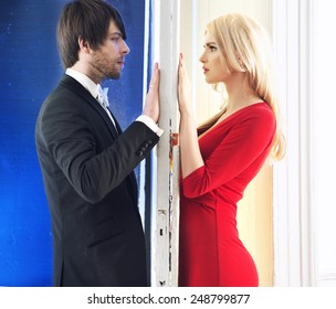 Attractive Couple Standing Next To A White Door