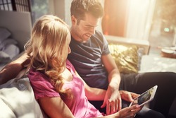 Attractive Couple Using Tablet Together On Futon H At Home