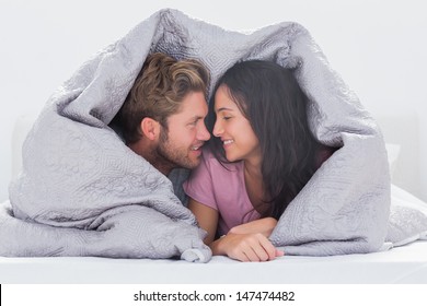 Attractive Couple Wrapped In The Duvet In Bed