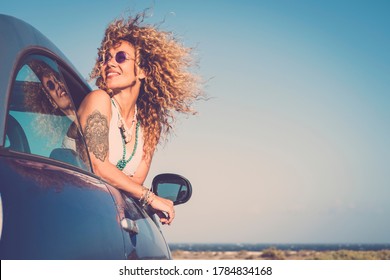 Attractive curly blonde young woman smile and enjoy the wind outside the car - concept of beauty and travel for happy and cheerful caucasian people - alternative lifestyle female feel the freedom joy - Shutterstock ID 1784834168