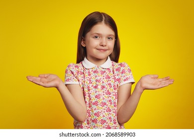 Attractive Cute Child With Arms Out, Shrugging Her Shoulders, Saying Who Cares, So What, I Dont Know, Isolated Over Yellow Background