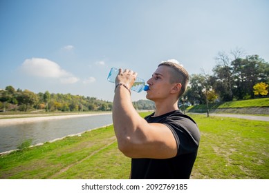 Attractive Dan Handsome Guy Is Drinking Water While Taking A Break From Training, By The River