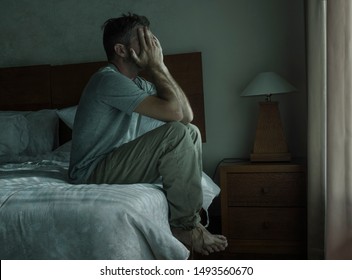 Attractive Depressed And Upset Man At Home Bedroom . Dramatic Lifestyle Portrait Of 30s To 40s Handsome Guy Sitting Sad On Bed Feeling Worried And Desperate Suffering Depression Problem 