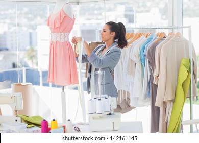 Attractive designer working on a dress in a studio - Powered by Shutterstock