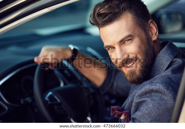 Attractive elegant happy\
man in good car