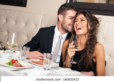 Attractive elegant young couple drinking a cocktail at the restaurant.