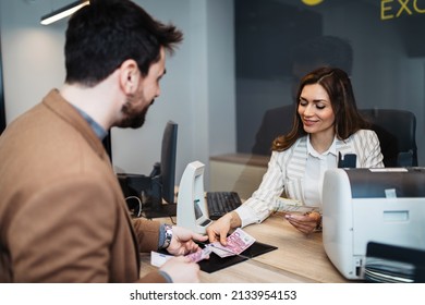 Attractive European Businesswoman Working In Exchange Office. She Is Giving Cash Money To Male Customer.