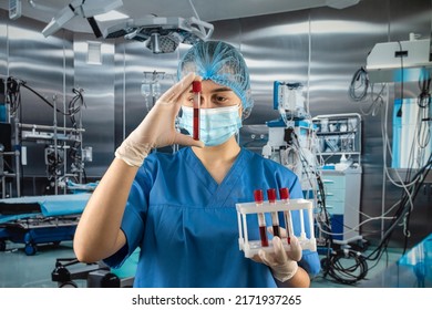 attractive experienced doctor wearing uniform facial mask protection gloves doing analysis blood probes patients at operating room in hospital - Shutterstock ID 2171937265