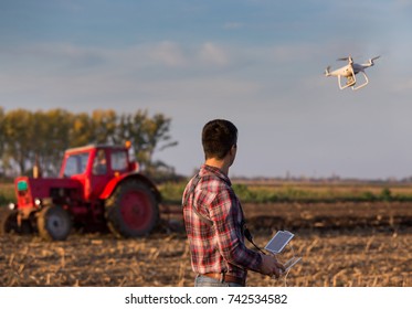 Attractive Farmer Navigating Drone Above Farmland. High Technology Innovations For Increasing Productivity In Agriculture