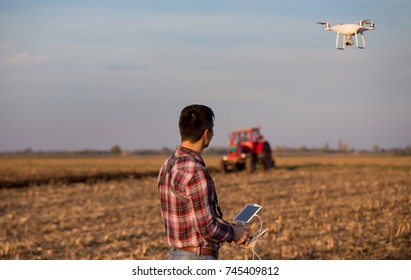 Attractive Farmer Navigating Drone Above Farmland. High Technology Innovations For Increasing Productivity In Agriculture