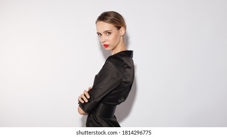 attractive fashinable woman in black dress and red lips posing isolated on white background