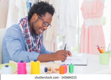 Attractive fashion designer sitting at his desk drawing in a creative office - Shutterstock ID 143684215