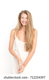 attractive fashion model with long blond hair posing in studio in white dress, simple make up, sexy body, smiling, laughing and grimacing, isolated on white background