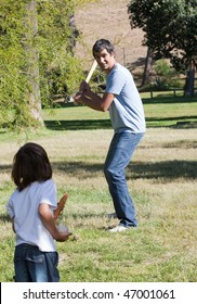 Attractive Father Playing Baseball With His Son In The Park