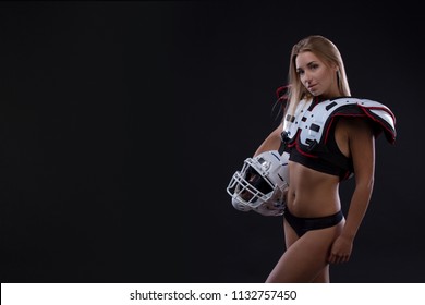 Attractive Female American Football Player In Uniform Posing With Helmet