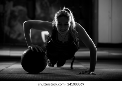 Attractive Female Athlete Performing Push-ups On Medicine Ball.Medicine Ball Push Up.Low Key