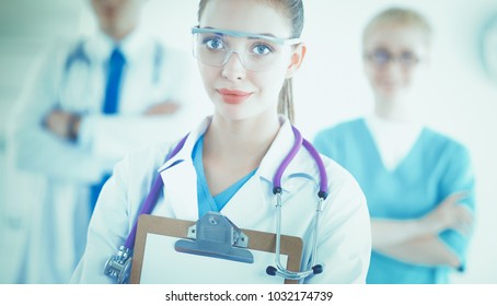 Attractive female doctor in front of medical group - Shutterstock ID 1032174739
