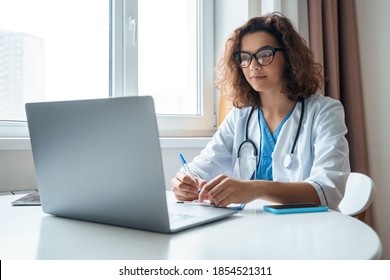 Attractive female doctor make online video call consult patient on laptop. Medical assistant young woman therapist videoconferencing to web camera. Telemedicine concept. Online doctor appointment.