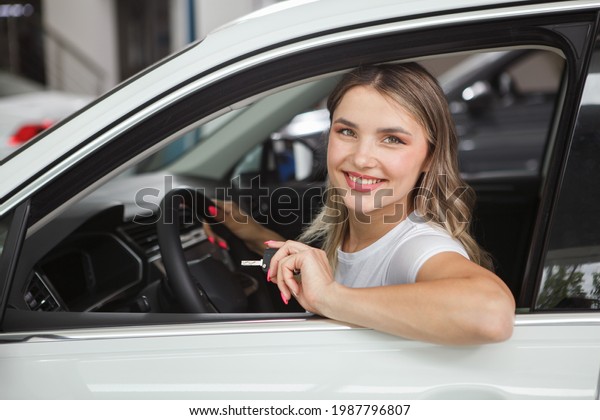 Attractive female\
driver smiling to the\
camera