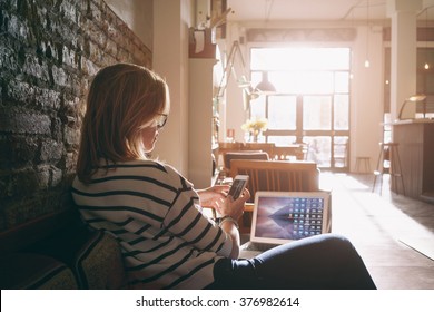 Attractive Female Freelancer Chatting With Her Friends  While Sitting Front Open Computer In Vintage Coffee Shop