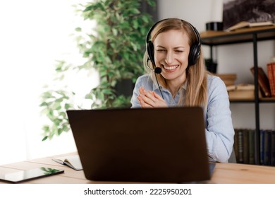 Attractive Female Freelancer Sitting At Work Desk And Having Business Online Meeting With Colleagues. Caucasian Mature Woman Wearing Headset And Using Portable Laptop.