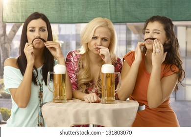 Attractive Female Friends Having Fun, Forming Moustache From Hair, Drinking Beer.