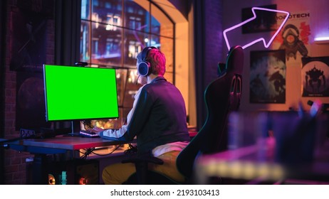 Attractive Female Gamer Playing Online Video Game With A Mock Up Green Screen On Her Powerful Computer. Room And PC Have Colorful Neon Led Lights. Cozy Evening At Home In Modern Apartment.