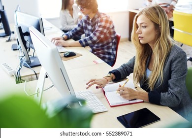 Attractive female international student making individual online testing and writing composition for annual exams preparation using computer,wireless connection to internet during lesson in library - Powered by Shutterstock