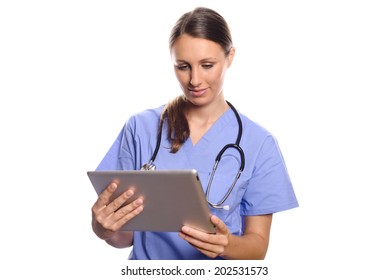 Attractive Female Nurse Or Doctor In A Mask Goggles And Surgical Gown Standing Consulting A Tablet Computer Reading The Information With A Serious Expression, Isolated On White