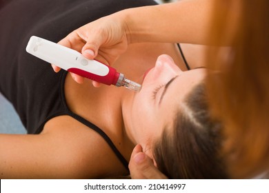 Attractive female patient receiving midro needle therapy on face as part of a anti-aging beauty treatment