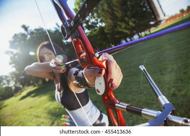 Attractive Female Practicing Archery At The Range. Focus Is On Bow