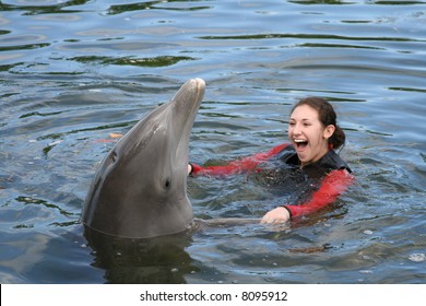 Attractive Female Teenager and a dolphin in the water