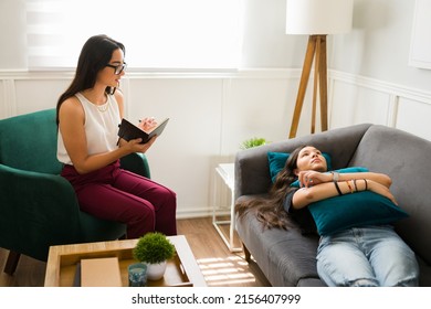 Attractive Female Therapist With Glasses Asking Questions About Her Problems To A Sad Teen Girl During A Therapy Session