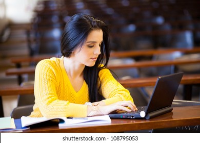 Attractive Female University Student Using Laptop In Classroom