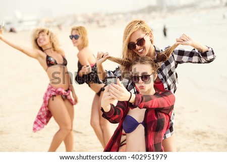 Attractive females making selfies at beach.