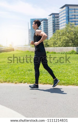 Attractive fit man running at sunset light