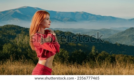 Attractive fit young woman having morning training on beautiful mountain background, Summer sunrise: girl's nature workout amid mountain fitness routine