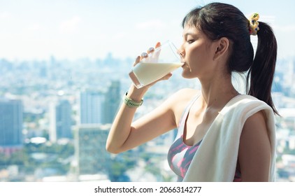 Attractive Fitness Asian Woman Finishing Workout And Drinking Protein Milk Shake Vitamins After Training. Bodybuilding. Healthy Lifestyle.city People Life Style Concept .