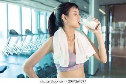 Attractive Fitness Asian Woman Finishing Workout And Drinking Protein Milk Shake Vitamins After Training. Bodybuilding. Healthy Lifestyle.