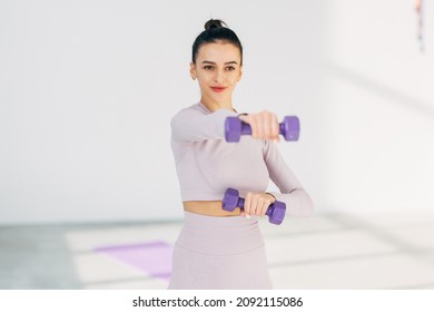 Attractive Fitness Woman Holding Dumbells At Gym Hall