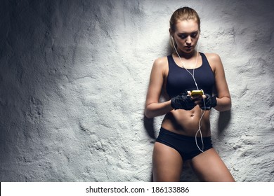 attractive fitness woman with mp3 player, caucasian brunette model - Powered by Shutterstock