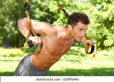 Attractive Fittness Man Doing Exercises In Park