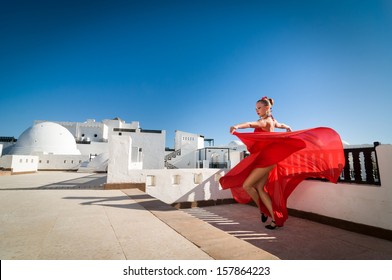 Attractive Flamenco Dancer Wearing Traditional Red Dress With Flower In Her Hair